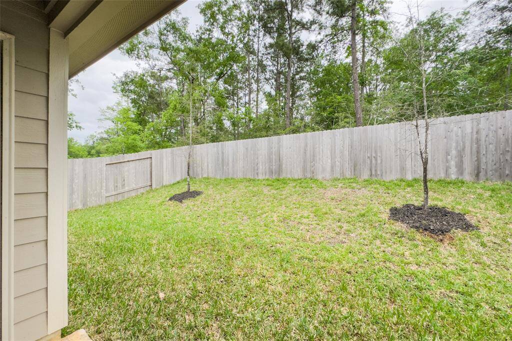 The home features a covered patio overlooking a beautiful scenery and mature trees.