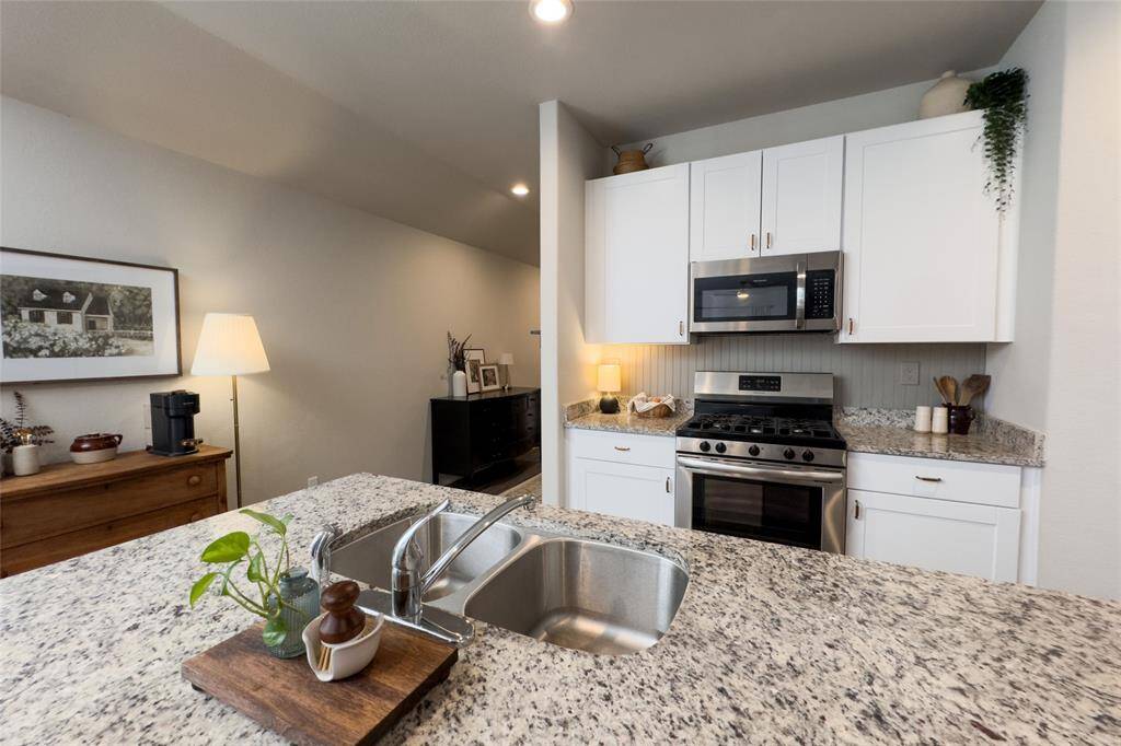 Check out this gorgeous kitchen featuring 42' white kitchen cabinets, updated gold hardware, updated backsplash, granite countertops, and freshly painted island that pulls everything together perfectly.