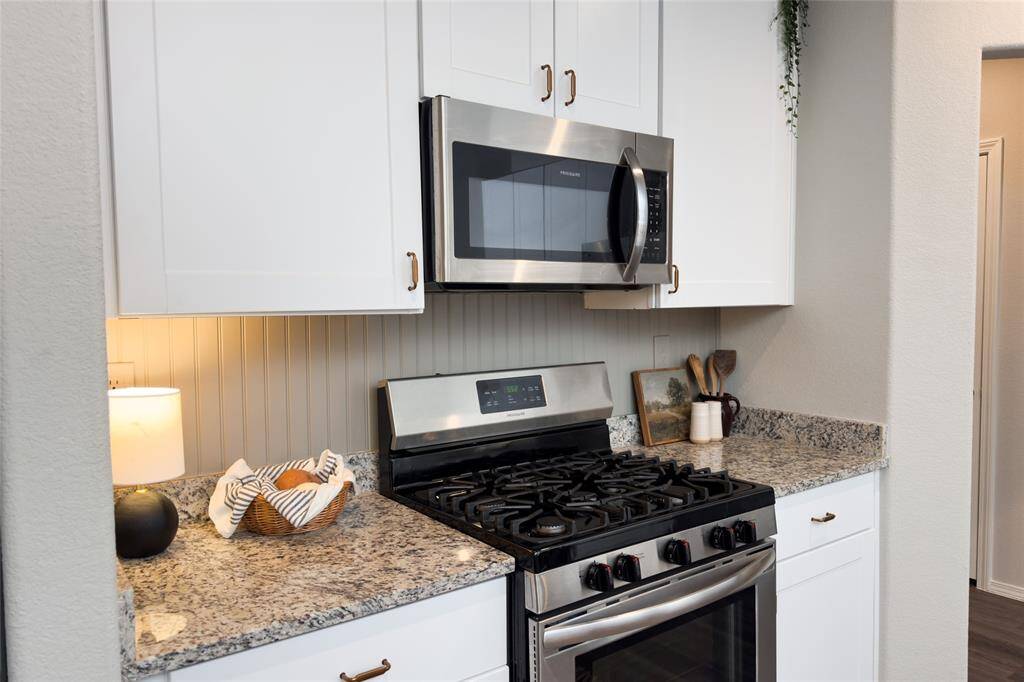 Check out this gorgeous kitchen featuring 42' white kitchen cabinets, updated gold hardware, updated backsplash, granite countertops, and freshly painted island that pulls everything together perfectly.