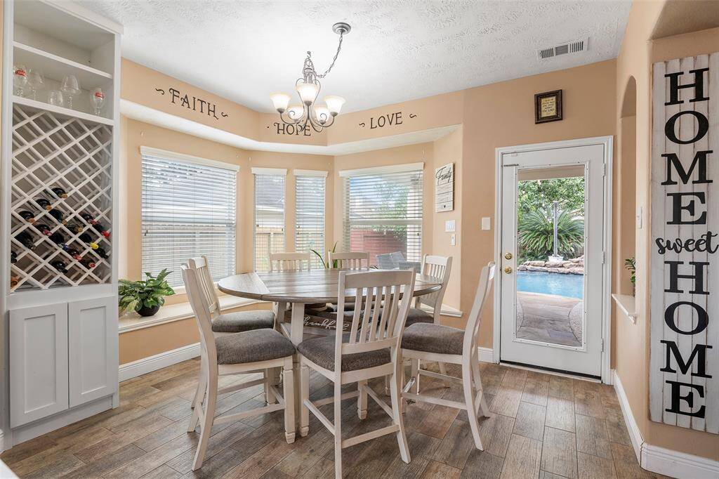 Take a look at this charming breakfast nook with large windows overlooking the backyard and pool. Bright, airy space perfect for morning coffee or casual dining.