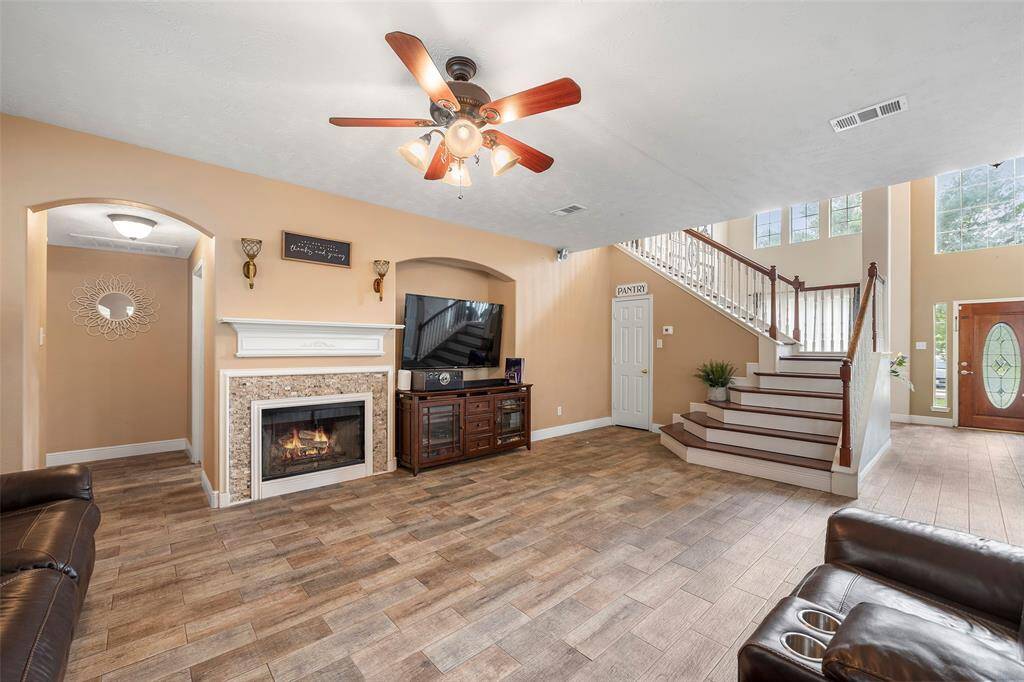 Comfortable and bright living area featuring a gas fireplace, large windows, and open sightlines to the rest of the home.