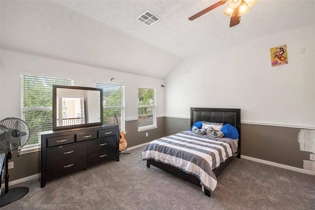 2nd Floor secondary bedroom features cozy carpeting, large closets, and bright natural light through large windows, complete with blinds for added privacy.