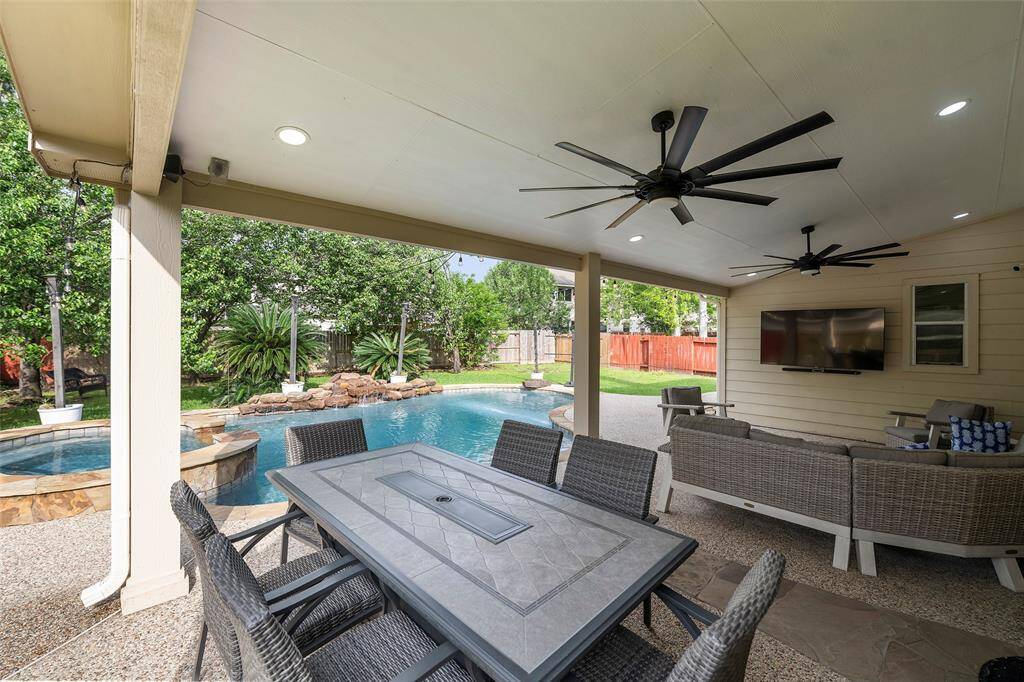 An entertainer’s dream! This backyard oasis boasts a gorgeous pool with spa, expansive covered patio with dual ceiling fans, outdoor dining area, and TV setup—ideal for hosting friends and family or relaxing on your own.