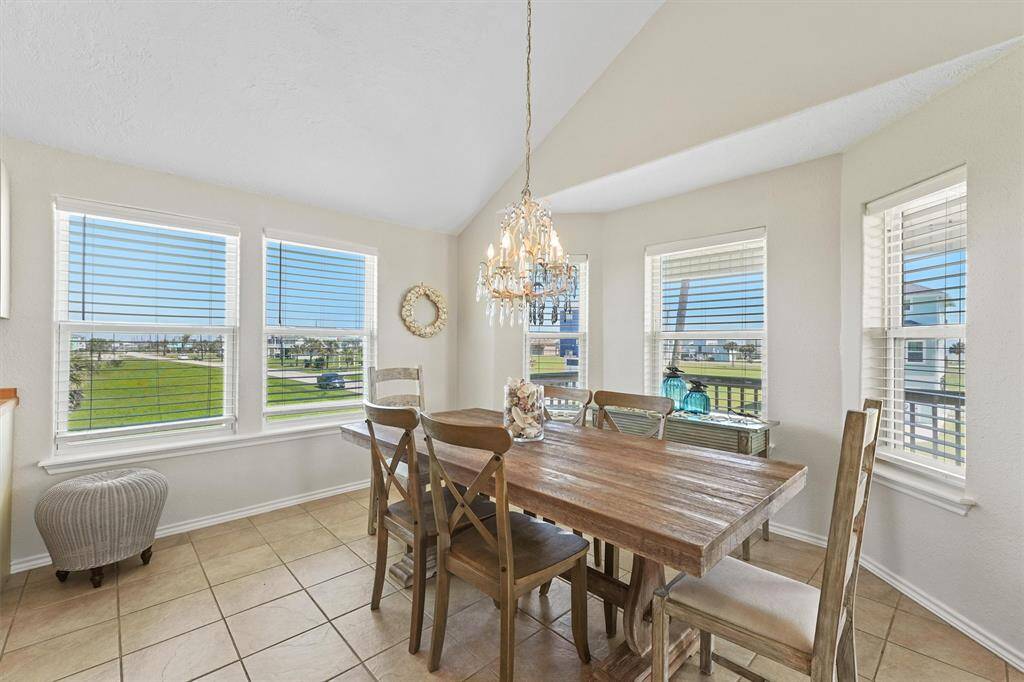 Light-filled dining area surrounded by windows with beautiful coastal views.