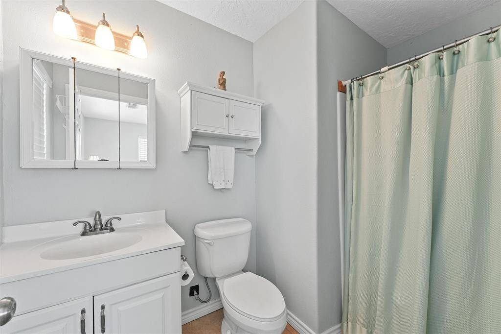 Primary bathroom with clean finishes, built-in storage, and a soft, airy feel.
