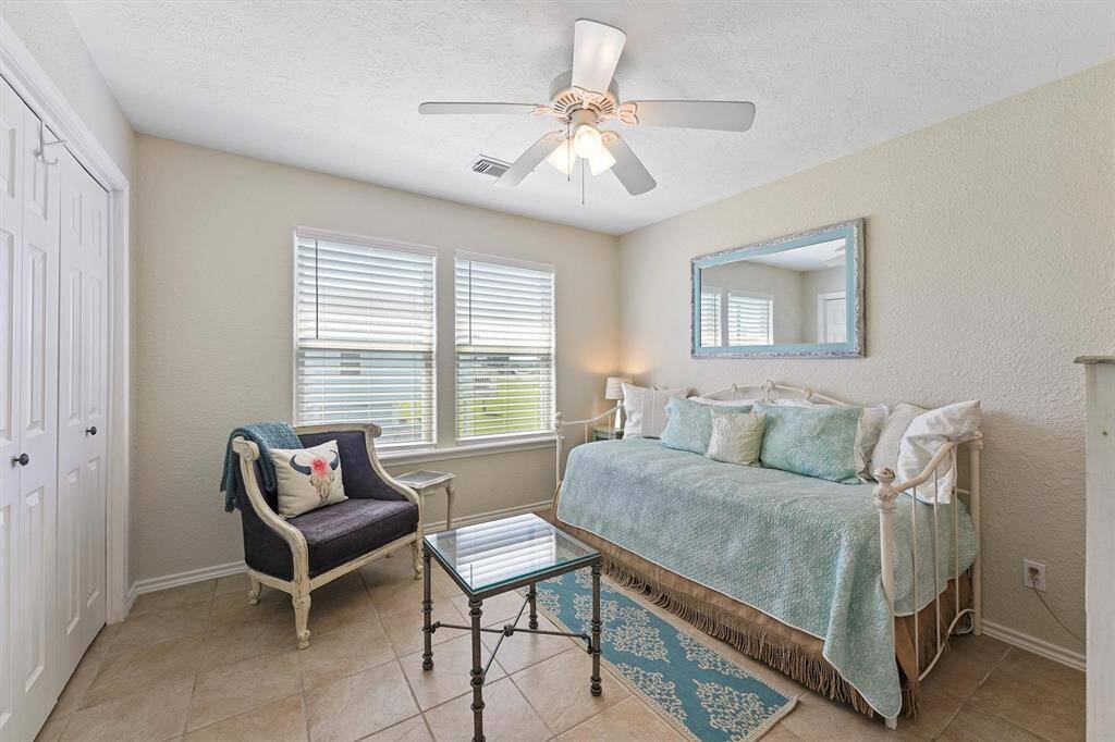 Guest bedroom featuring a charming daybed, classic furnishings, and plenty of natural light.