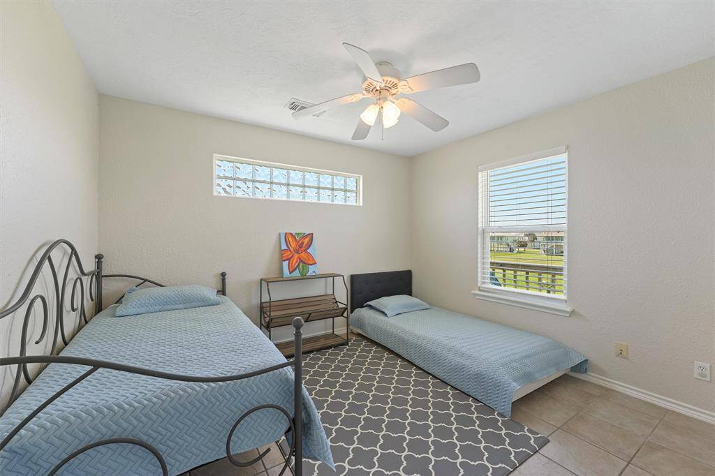 Additional guest bedroom with twin sleeping setup and a cheerful window view.