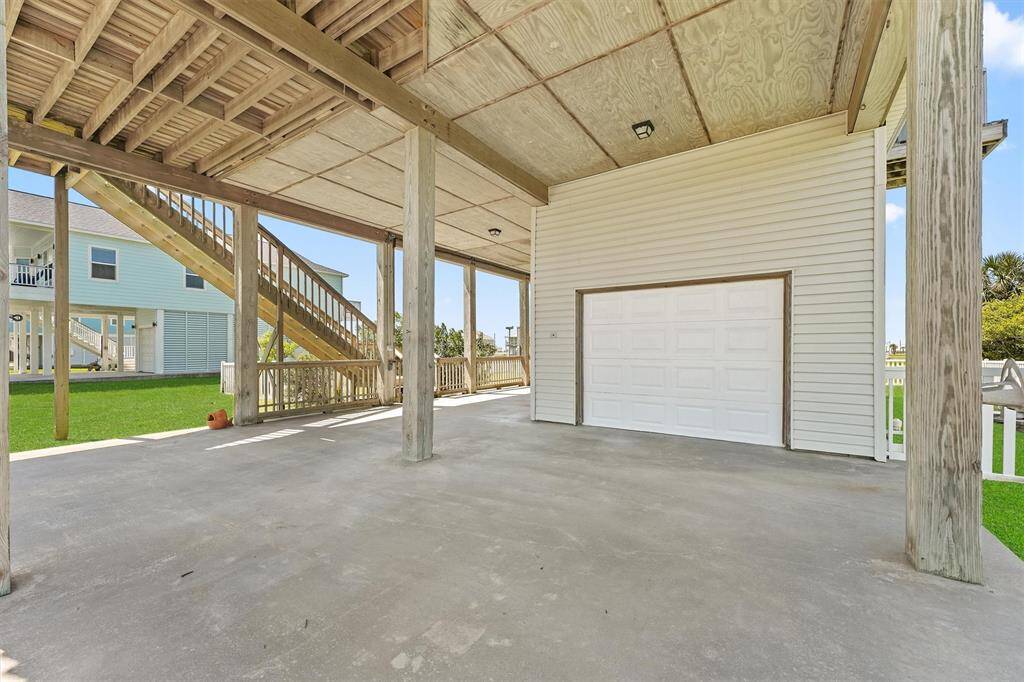 Covered ground-level parking with ample space for vehicles and beach toys, plus a private garage.