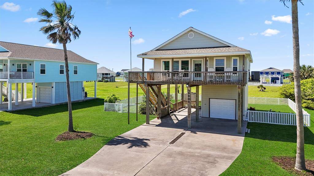 Angled front shot highlighting the expansive driveway, balcony seating, and corner lot setting.