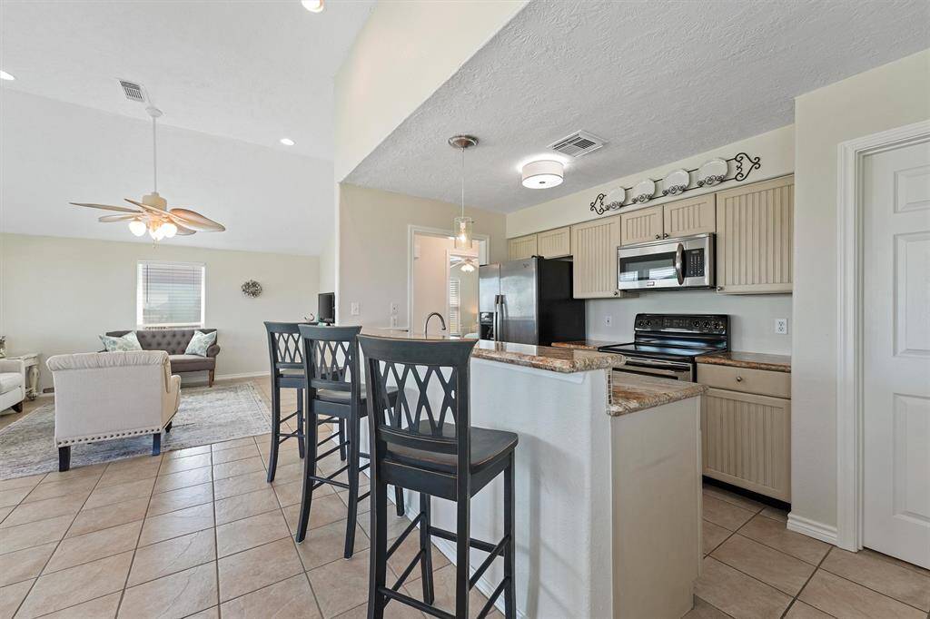 Kitchen flows seamlessly into the living area with a breakfast bar and updated appliances.