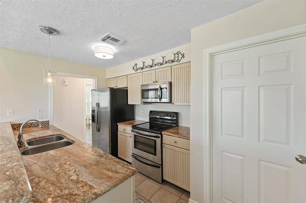 Well-appointed kitchen with granite countertops, ample cabinetry, and stainless appliances.