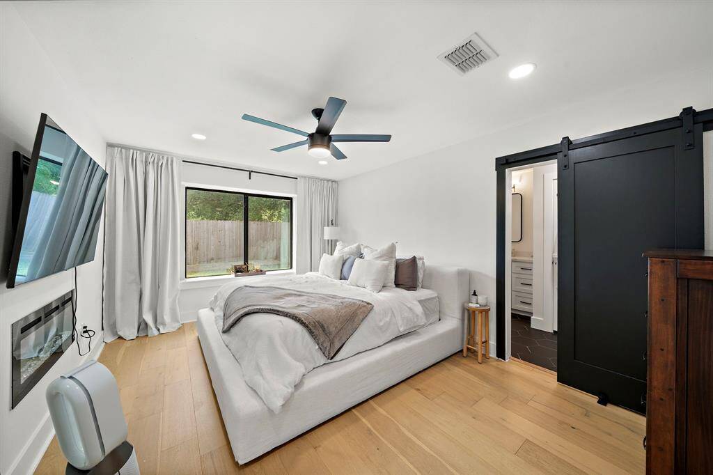 Primary Bedroom with built in fire place and barn door to the en-suite