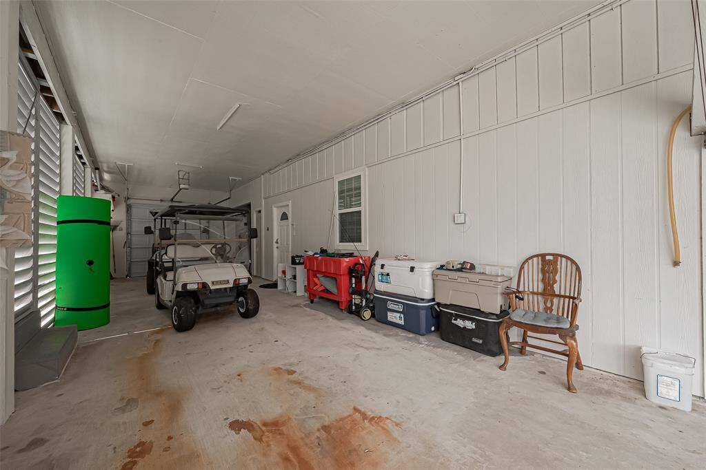 Garage features ample storage space with shelving and room for additional vehicles or equipment making it functional for various needs.