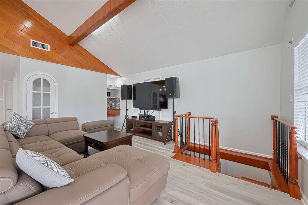 Stylish railing around the stairway. Natural light flows in through the window, creating a bright and inviting space. Check out the wine bar and an extra sink!