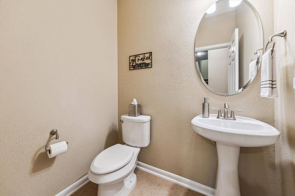 The spacious powder room is pristine and thoughtfully designed, offering both style and functionality.