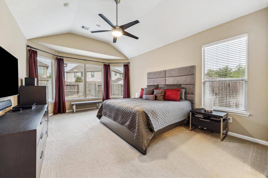 The expansive primary bedroom features soaring ceilings and a charming bay window, adding both space and character to your private retreat.