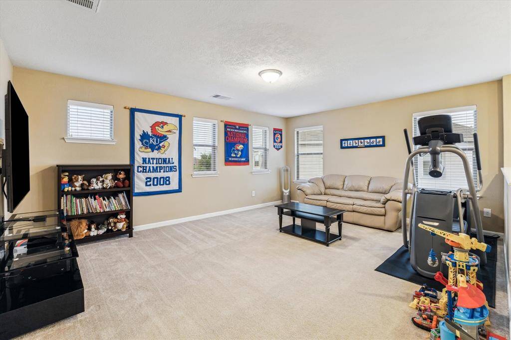 At the top of the stairs, you're welcomed by a spacious game room filled with natural light from an abundance of windows.