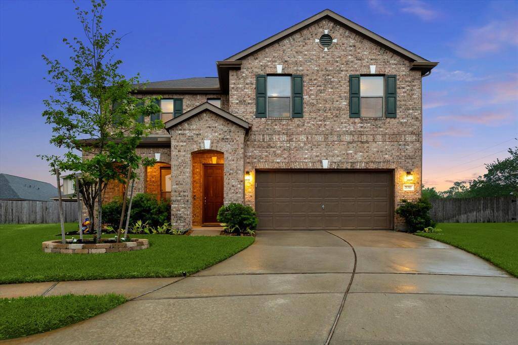 This stunning home features a classic brick exterior, a charming covered porch, and a wide double driveway for added convenience and curb appeal.