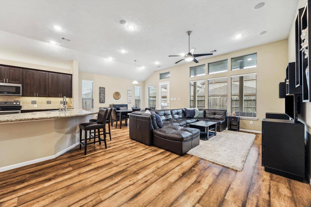From this vantage point, you’ll notice the seamless flow from the kitchen to the living room. Soaring ceilings and tall windows fill the space with natural light, while built-in speakers add a touch of luxury to your everyday living.