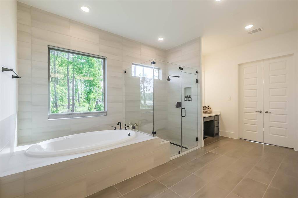 Soak after a long day in your jacuzzi tub, or perhaps you prefer the large seamless glass shower that features a built in bench. Privacy shades on the window can go up or down