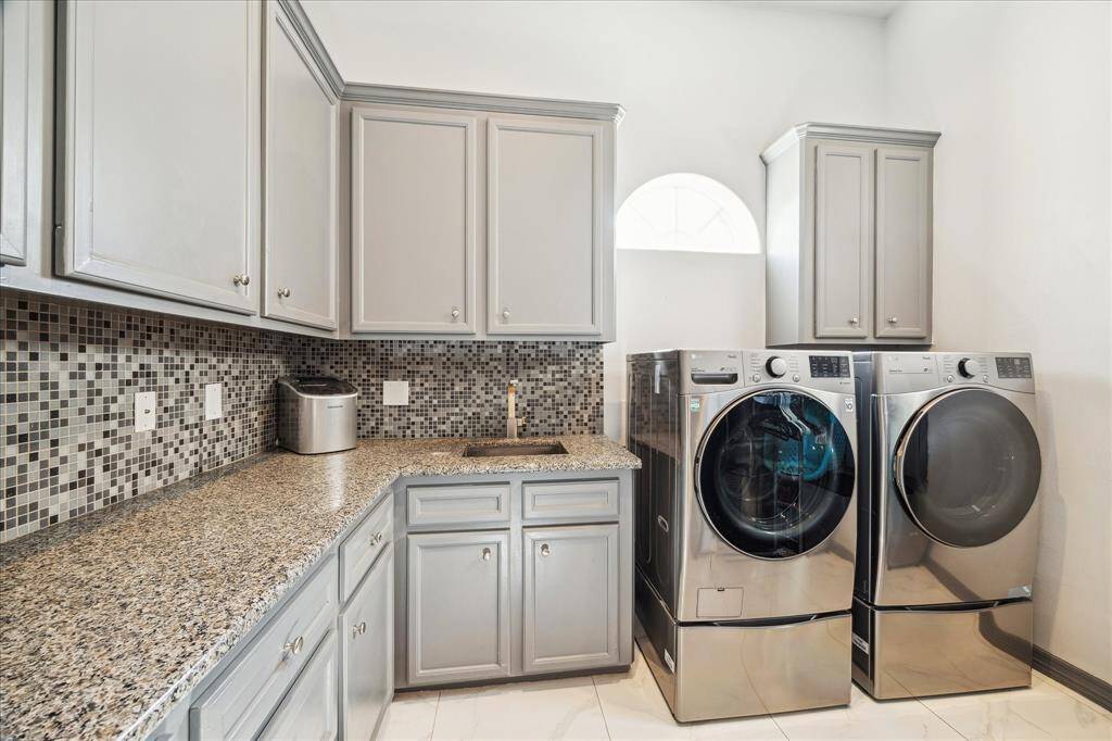 This luxurious bathroom features a stylish freestanding tub, a spacious glass-enclosed shower with intricate tile work, state of the art shower head, and elegant lighting fixtures. Perfect for relaxation and modern comfort.