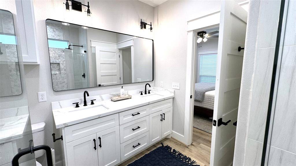 Bath 1 with double sinks, large shower with custom tile and linen closet