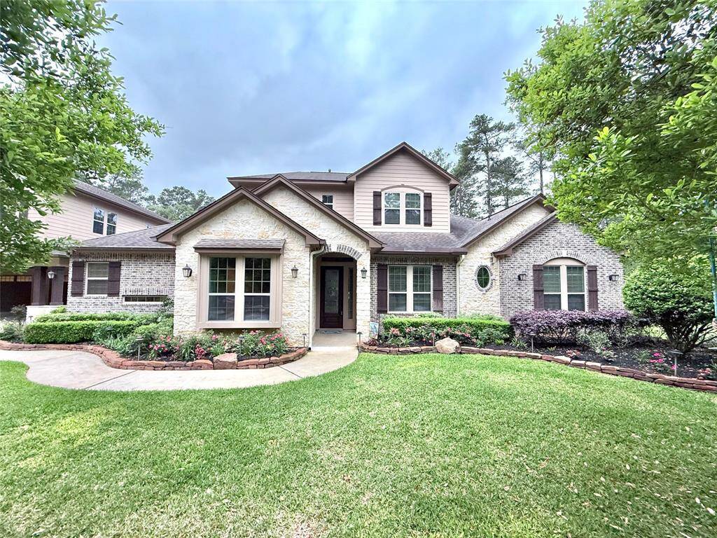 Front view of the house featuring the stone and brick and upgraded landscape lighting.