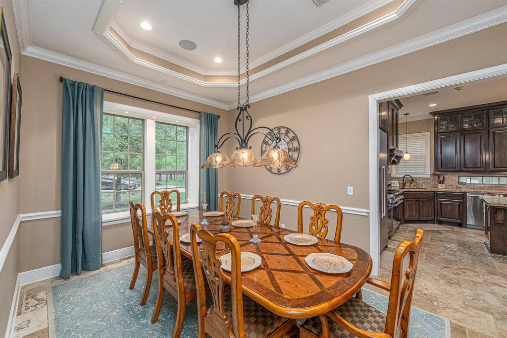 Spacious dining room with tray ceilings.