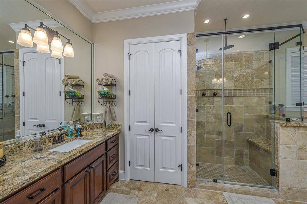 Spacious master bathroom with chandelier, soaking tub, separate stand-alone shower, and separate sinks.