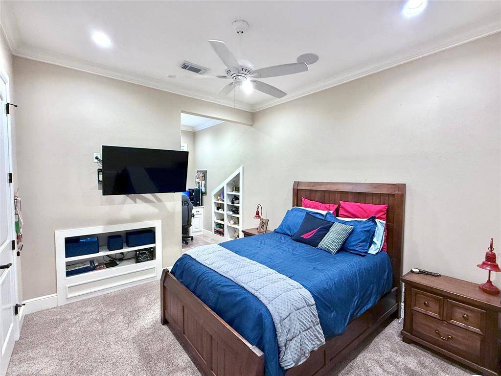 This spacious bedroom is upstairs with an en-suite bathroom, custom closet built-in shelving and drawers, and dormer with custom built-in desk and shelving.