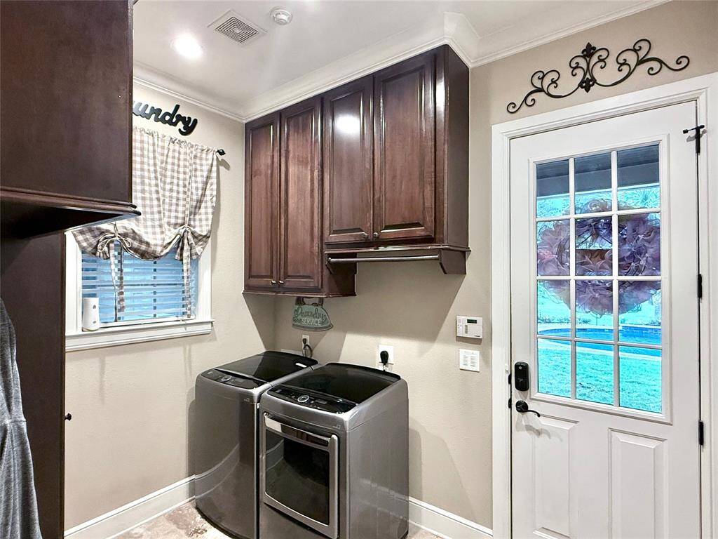 Utility room with custom built-in cabinets and bench. Gas and electric connections for dryer.