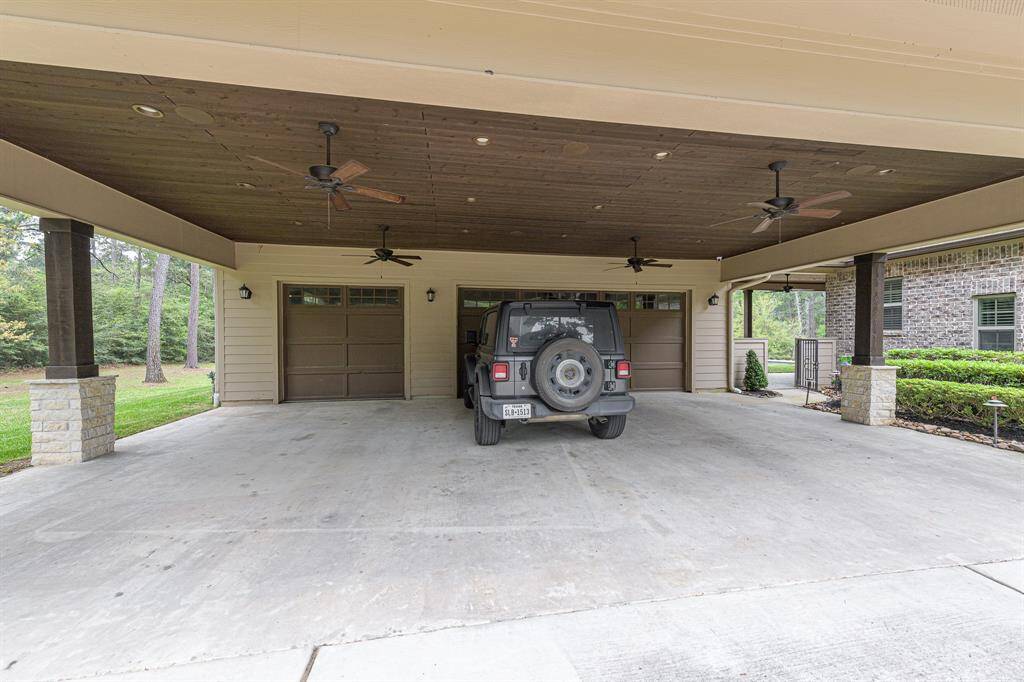 Close up of carport which has several fans, recessed cans, and speakers.