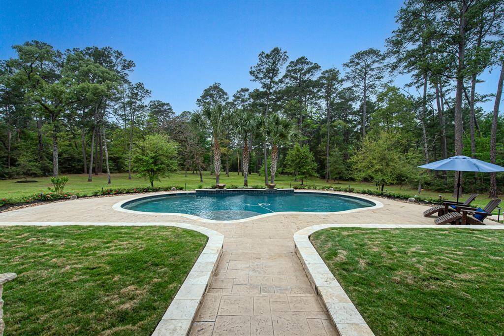 When you exit the back doors of the house, you walk onto the patio with a view of the beautiful pool.