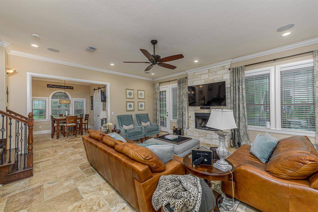The living room features a gas, log-log burning stone fireplace.