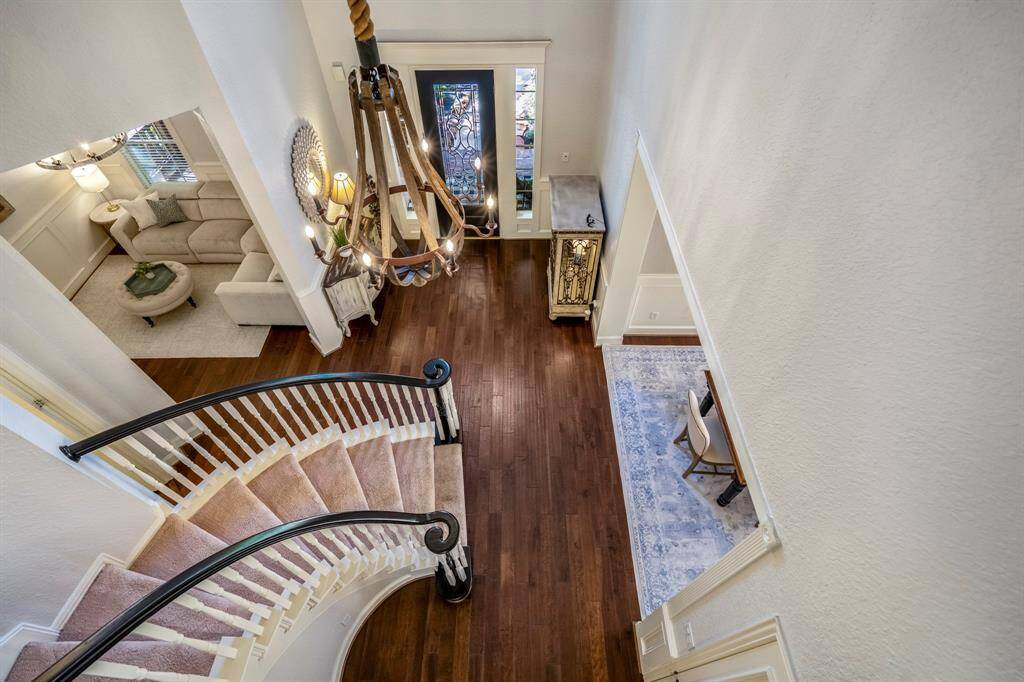 Elegant view from the staircase showcasing a spacious, inviting entryway with warm hardwood floors and stylish decor.