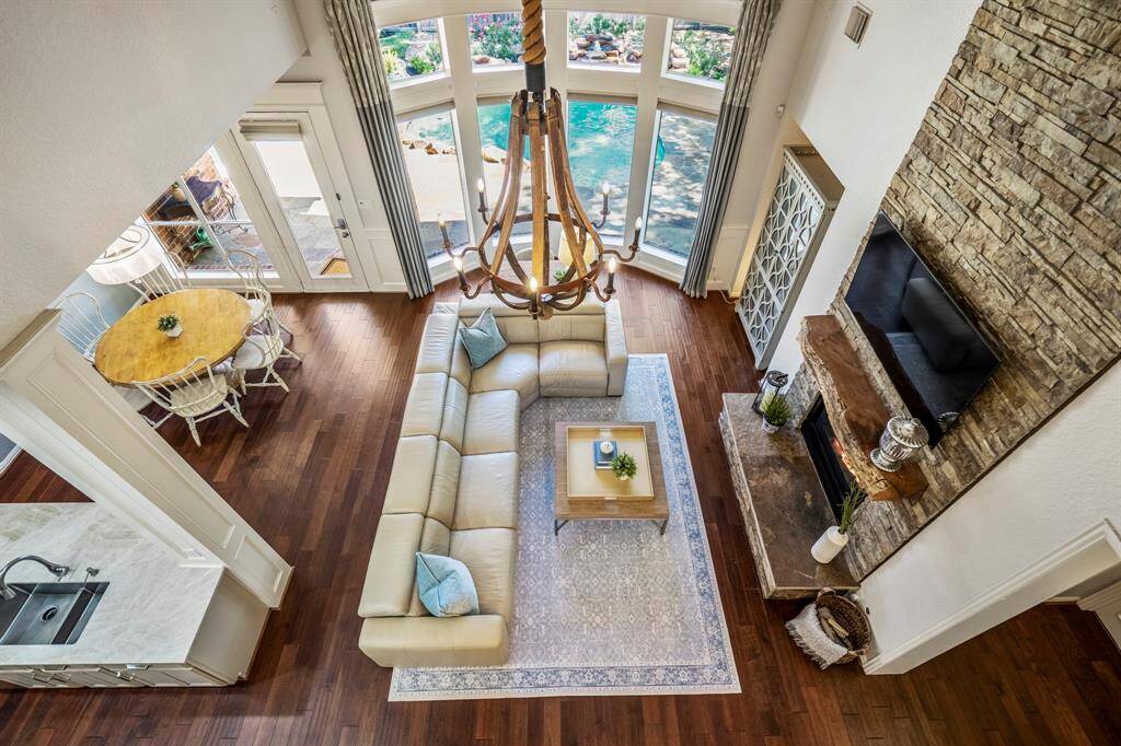 Stunning aerial view from the stairs showcasing a spacious living area, elegant fireplace, and scenic outdoor pool.