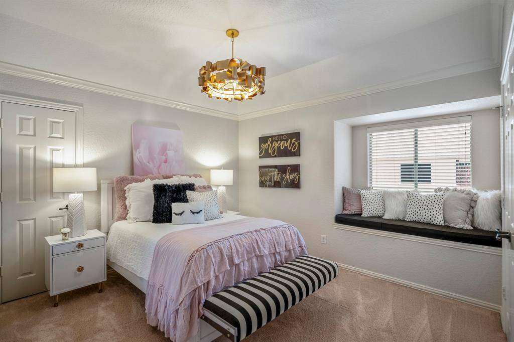 Luxurious upstairs bedroom featuring a stylish chandelier and cozy window seat.