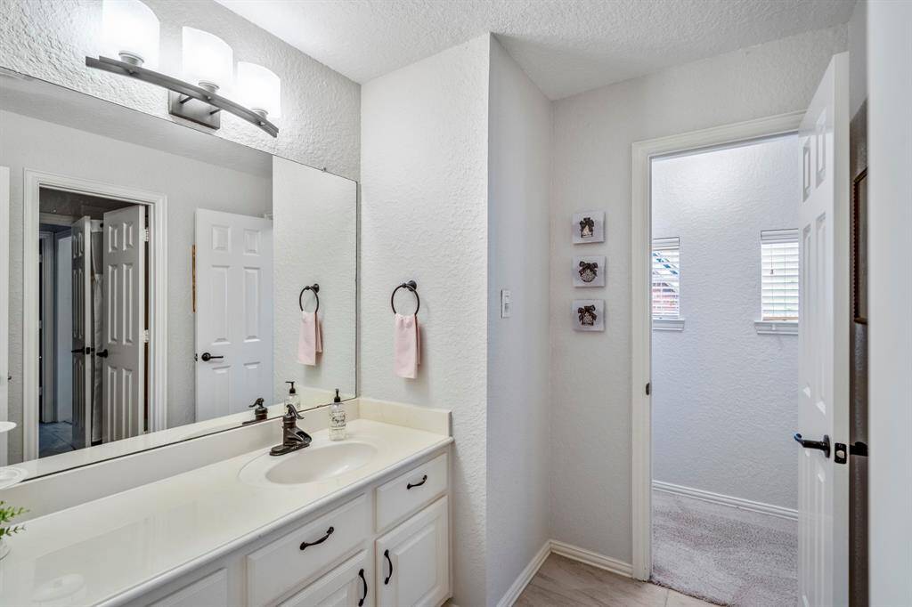 This bedroom features a convenient en-suite half bathroom attached to the shared full bath, perfect for added privacy and functionality.