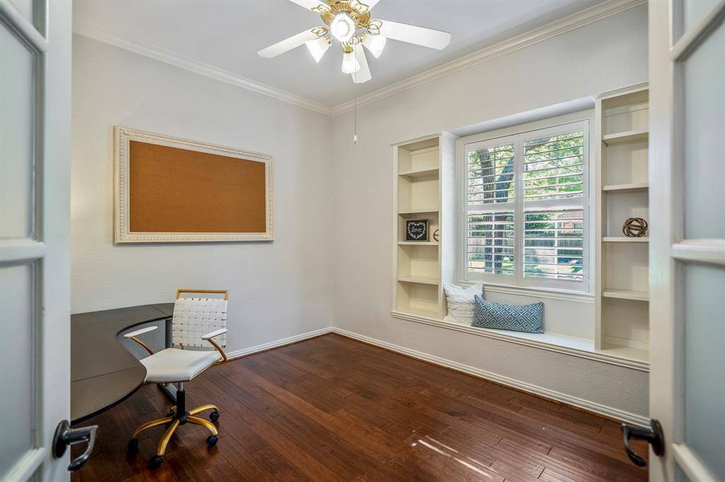 Charming office with built-in shelves and a cozy window seat, perfect for productivity and relaxation.