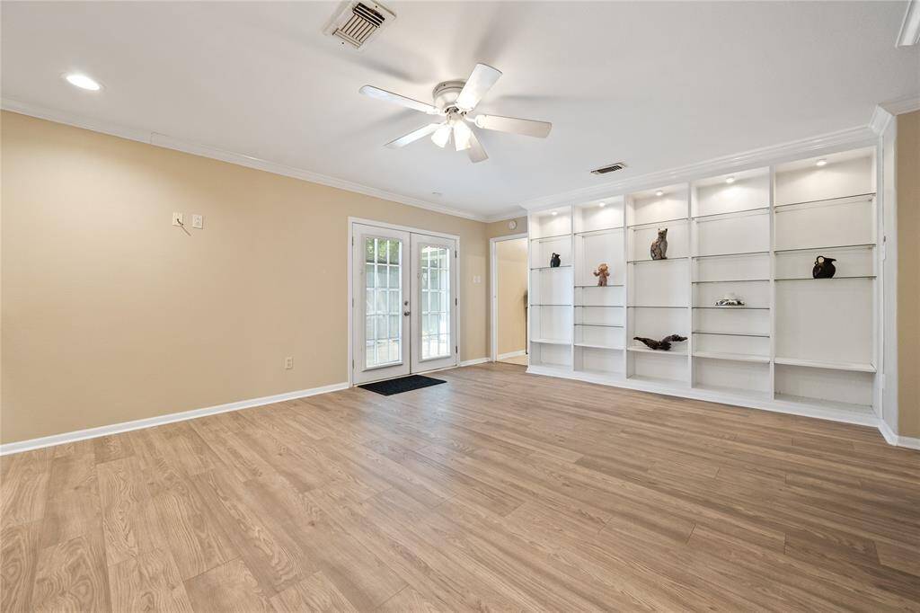 Primary bedroom offers both functionality and style featuring light flooring, neutral walls, ceiling fan, a mirrored closet, and an en suite bathroom,