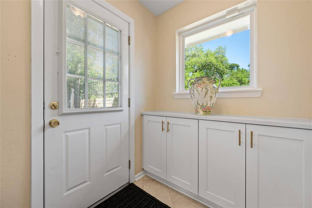 This secondary bedroom features neutral walls, light flooring, and a ceiling fan. Natural light enters through a window with blinds.