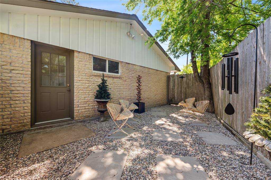 Tranquil side patio with elegant wrought iron gate and inviting seating area.