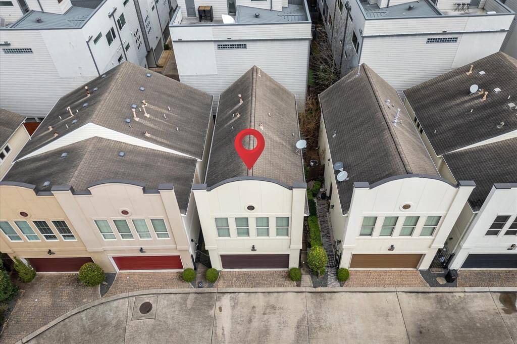 Modern townhouse with a two-car garage, situated in a row of similar homes. Features a paved driveway and neatly trimmed greenery. Ideal for a buyer seeking a low-maintenance, contemporary living space.
