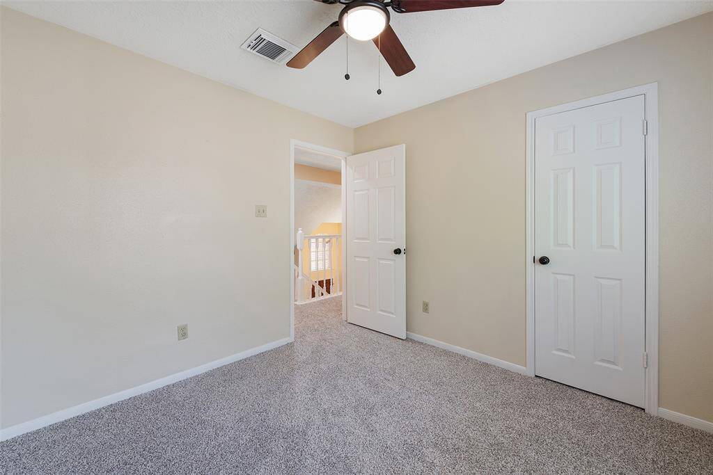 Bedroom with lighted ceiling fan.