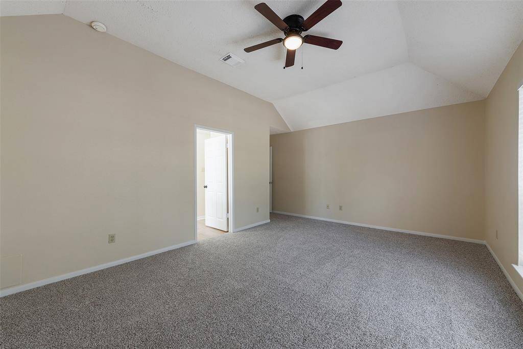 Primary bedroom is spacious & has a lighted ceiling fan.