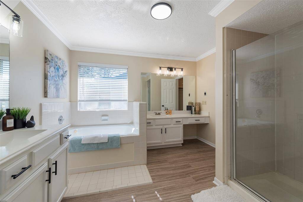 Whirlpool tub with tile surround & a walk-in closet.