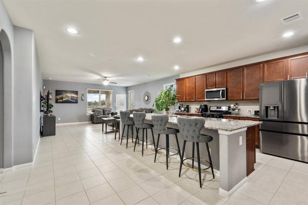 This fully equipped kitchen features an oversized island, an abundance of cabinetry and hardware, TONS of counter space, granite countertops and stainless-steel appliances.