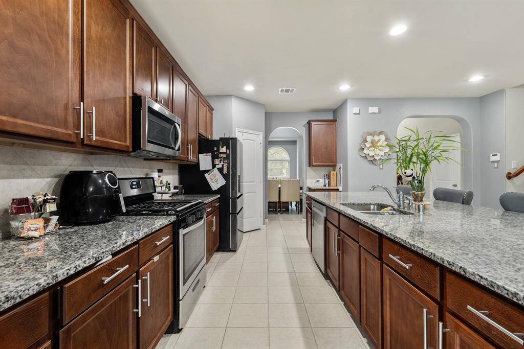 It is complete with tile floors, recessed lighting, and a walk-in pantry.