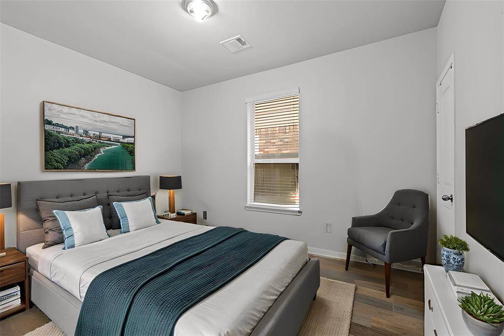 Virtually Staged: Secondary bedroom downstairs featuring engineered wood floors, and a window with privacy blinds.