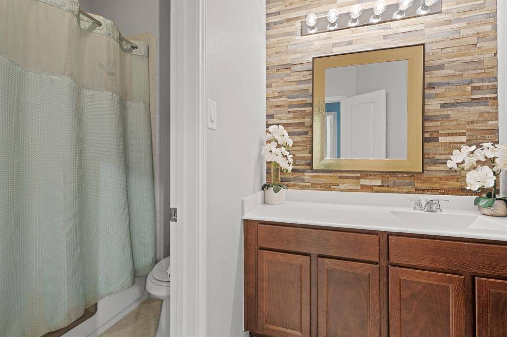 The bathroom is complete with a shower/tub combo.